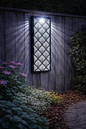 Decorative outdoor light fixture on a wooden wall with plants and flowers in the foreground.