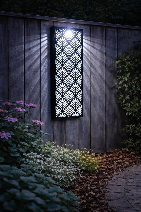 Decorative outdoor light fixture on a wooden wall with plants and flowers in the foreground.