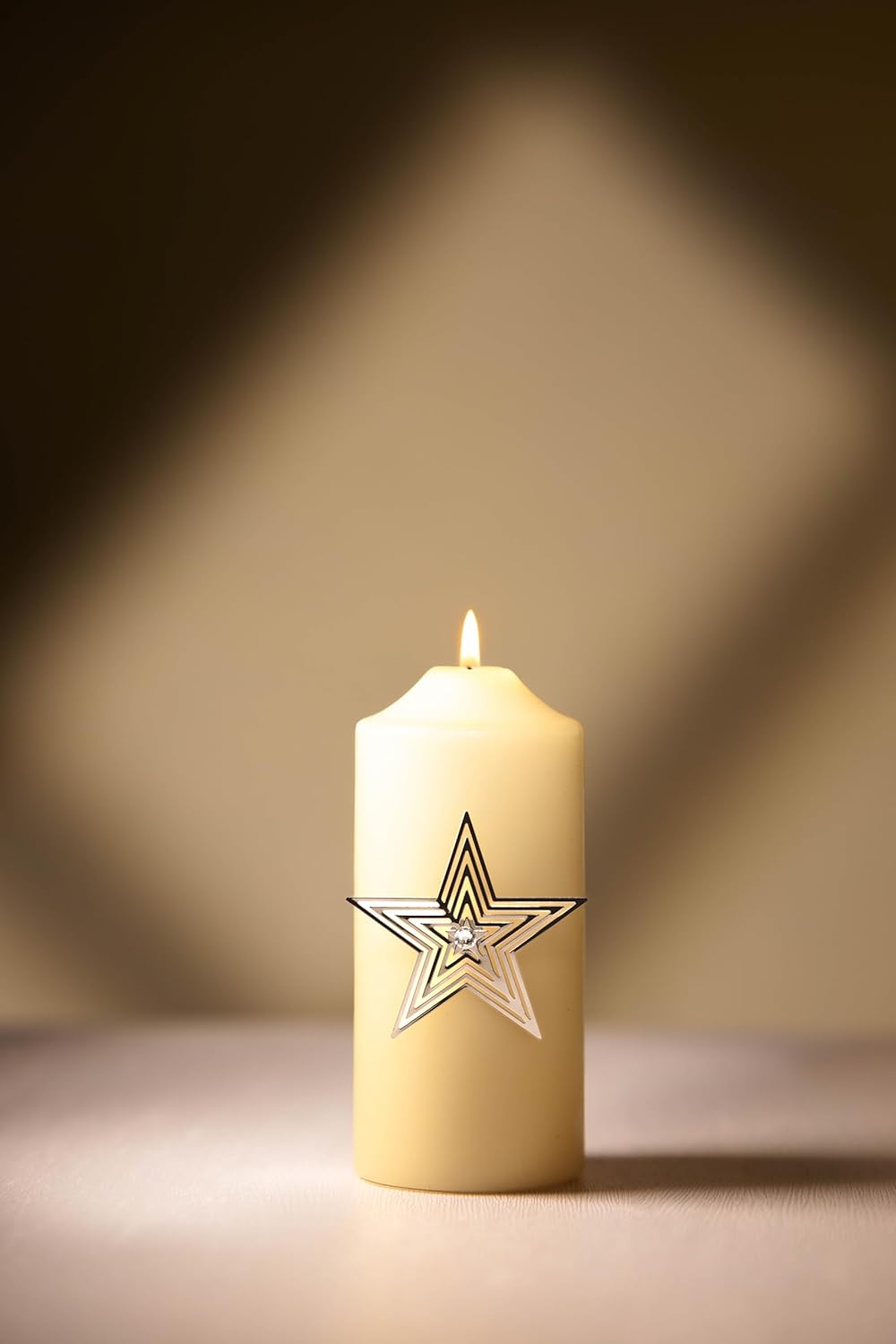 White candle with a star design on a dark background