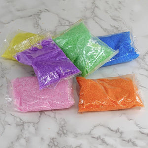 Colorful sand or powder samples in clear plastic bags on a marble surface