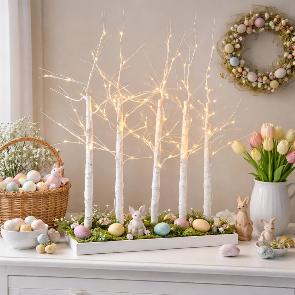 Decorative Easter scene with lighted trees, Easter eggs, and a wreath on a wall.