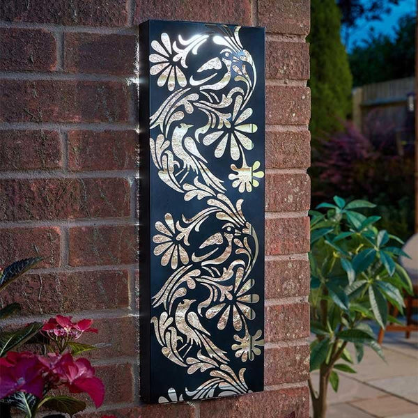 Decorative metal wall art with floral patterns on a brick wall