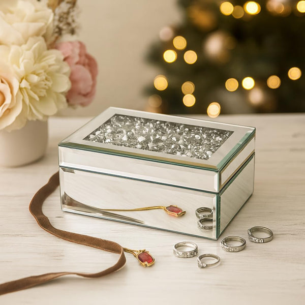 Decorative jewelry box with rings and a ribbon on a table with a blurred festive background