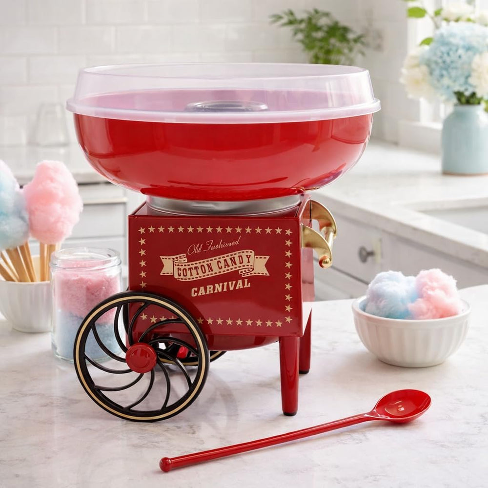 Red cotton candy maker with a bowl of cotton candy on a table.