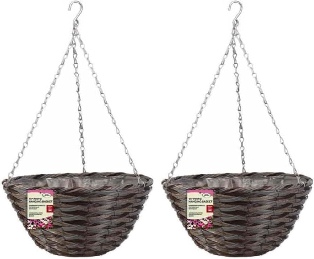 Two hanging flower baskets with flowers against a brick wall.