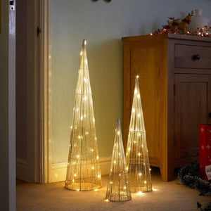 Set of three illuminated decorative Christmas trees in a room setting.