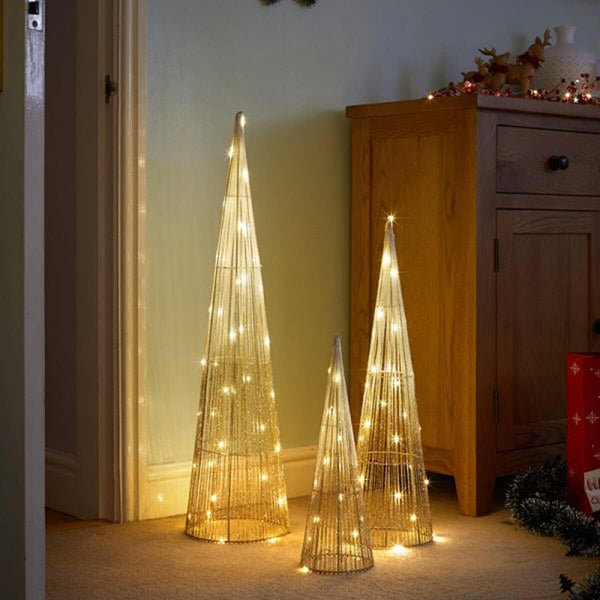 Set of three illuminated decorative Christmas trees in a room setting.