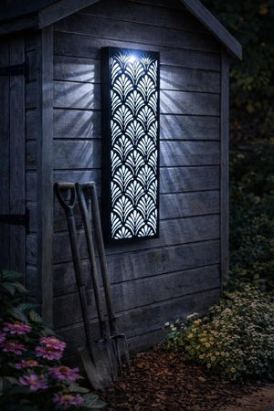 Decorative wall light on a wooden shed exterior with garden tools and flowers.