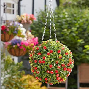 Hanging flower basket with red flowers in a garden setting