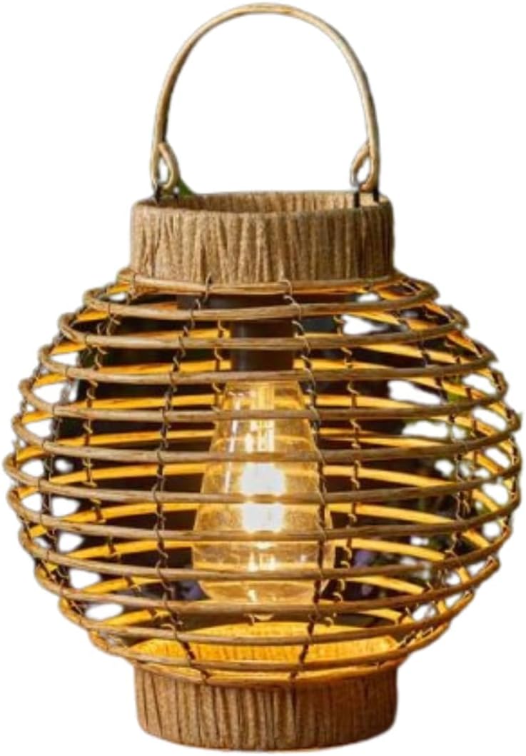 Wicker lantern on a wooden surface with plants in the background