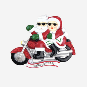 Decorative ornament of Santa and Mrs. Claus on a motorcycle with 'Merry Christmas' text.