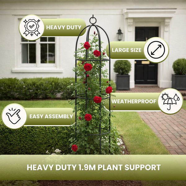 A black metal garden trellis support stand shown in a real front yard with a house, lawn, and planters in the background. The trellis is covered with climbing red roses.
