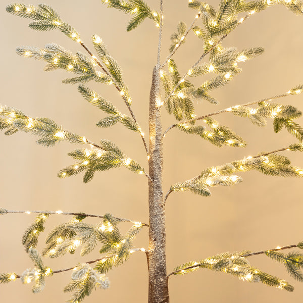 Large LED twig tree displayed beside fireplace