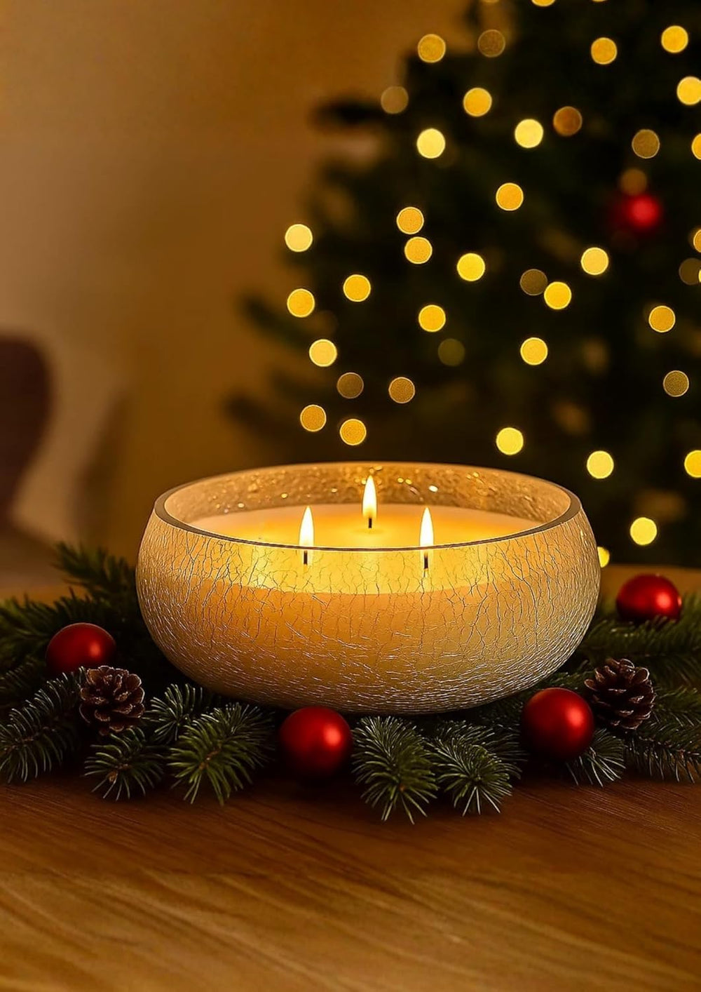 Lit candle in a decorative bowl with Christmas decorations and a tree in the background
