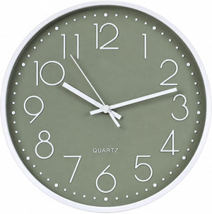 A minimalist wall clock with a sage green dial, white frame, and white numerals and hands, labeled 'QUARTZ'.