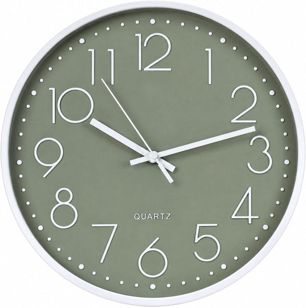 A minimalist wall clock with a sage green dial, white frame, and white numerals and hands, labeled 'QUARTZ'.