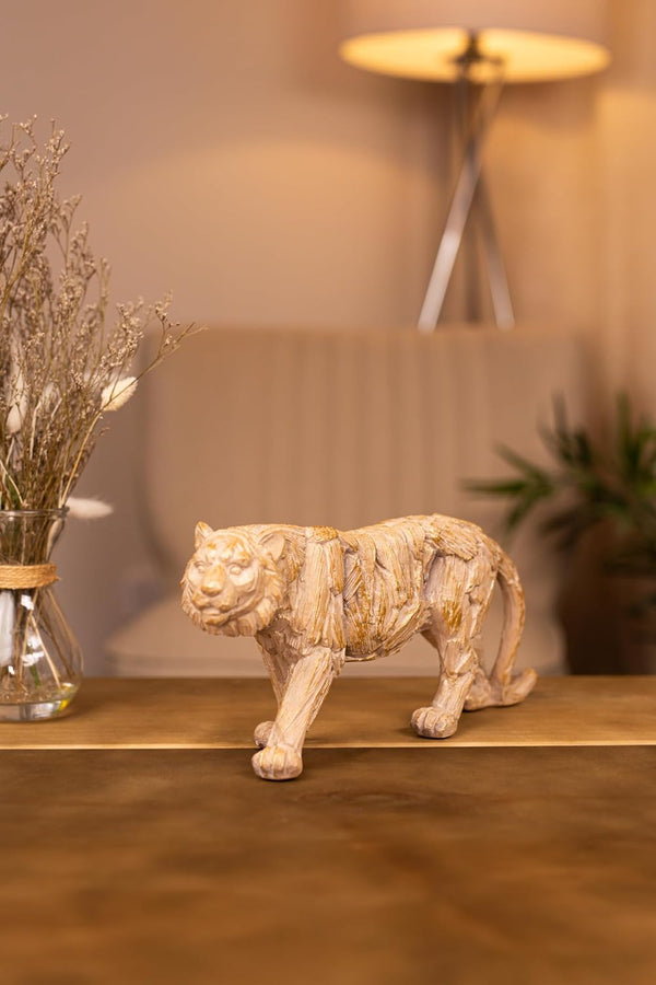 Decorative tiger statue on a wooden surface with a blurred background