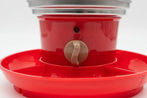 Red plastic feeder with a white background