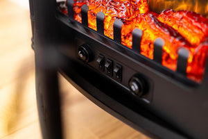 Close-up of a fire pit with glowing embers and control buttons.