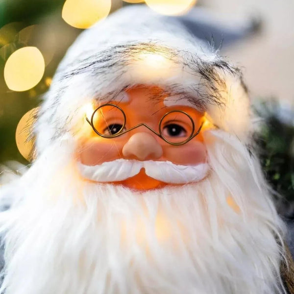 Close-up of a Santa Claus figure with blurred lights in the background