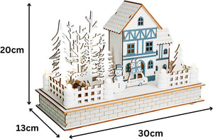 Model of a snowy village scene with a house, trees, and deer, showing dimensions on a white background.