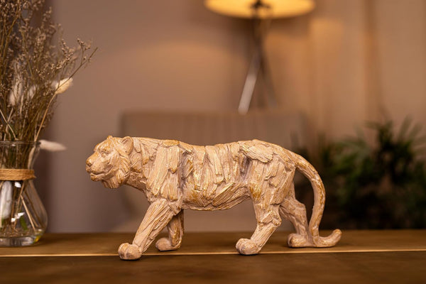 Wooden sculpture of a tiger with detailed texture on a dark background