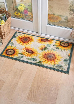 Decorative doormat with sunflower design on a wooden floor.