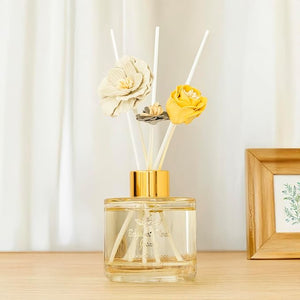 Decorative diffuser with floral elements on a wooden surface