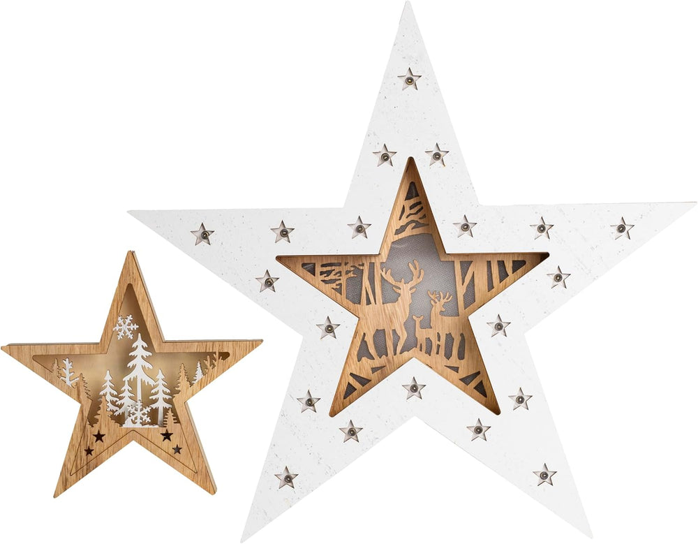 Wooden star-shaped lamps with glowing interior on a wooden surface, blurred Christmas tree in the background.