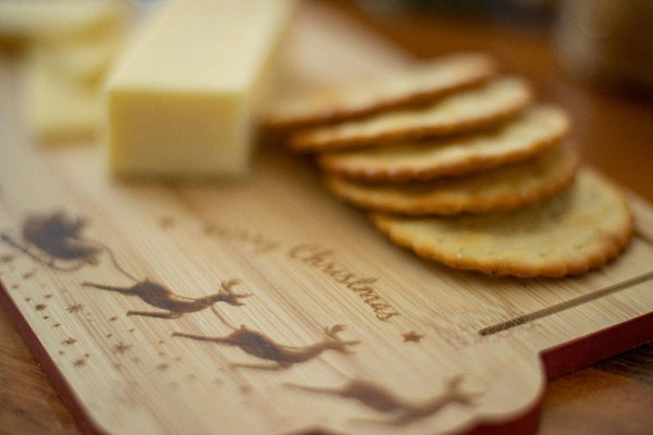Wooden board with cheese and crackers on a wooden surface
