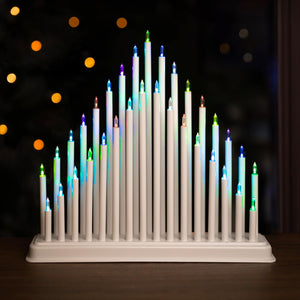 Decorative candle holder with multicolored candles against a dark background