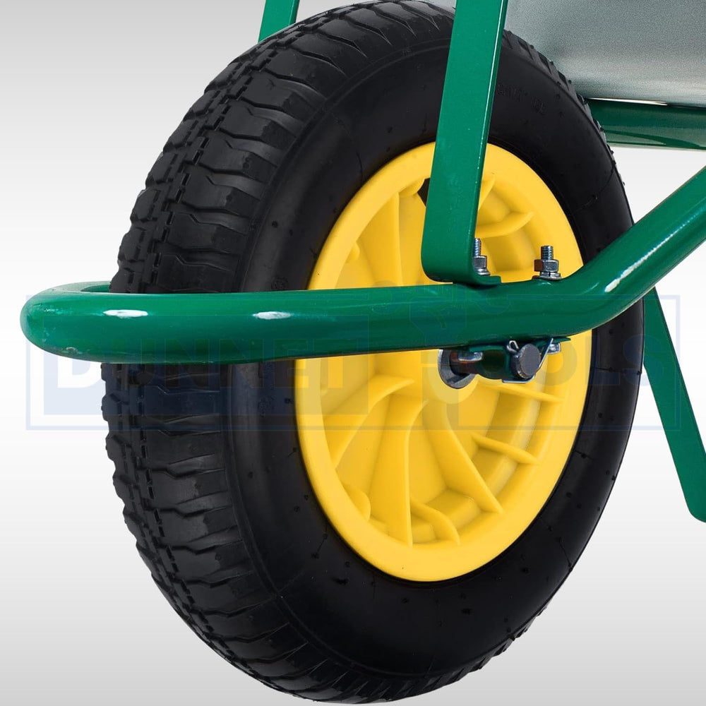 Close-up of a green wheelbarrow wheel with a yellow rim, attached to a metal frame.
