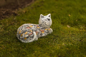 Cat-shaped stone sculpture on a grassy surface