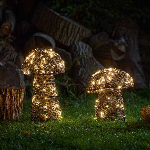 Decorative mushroom lights with string lights on a grassy area