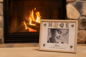 Framed photo with 'Home is where the heart is' text in front of a fireplace.