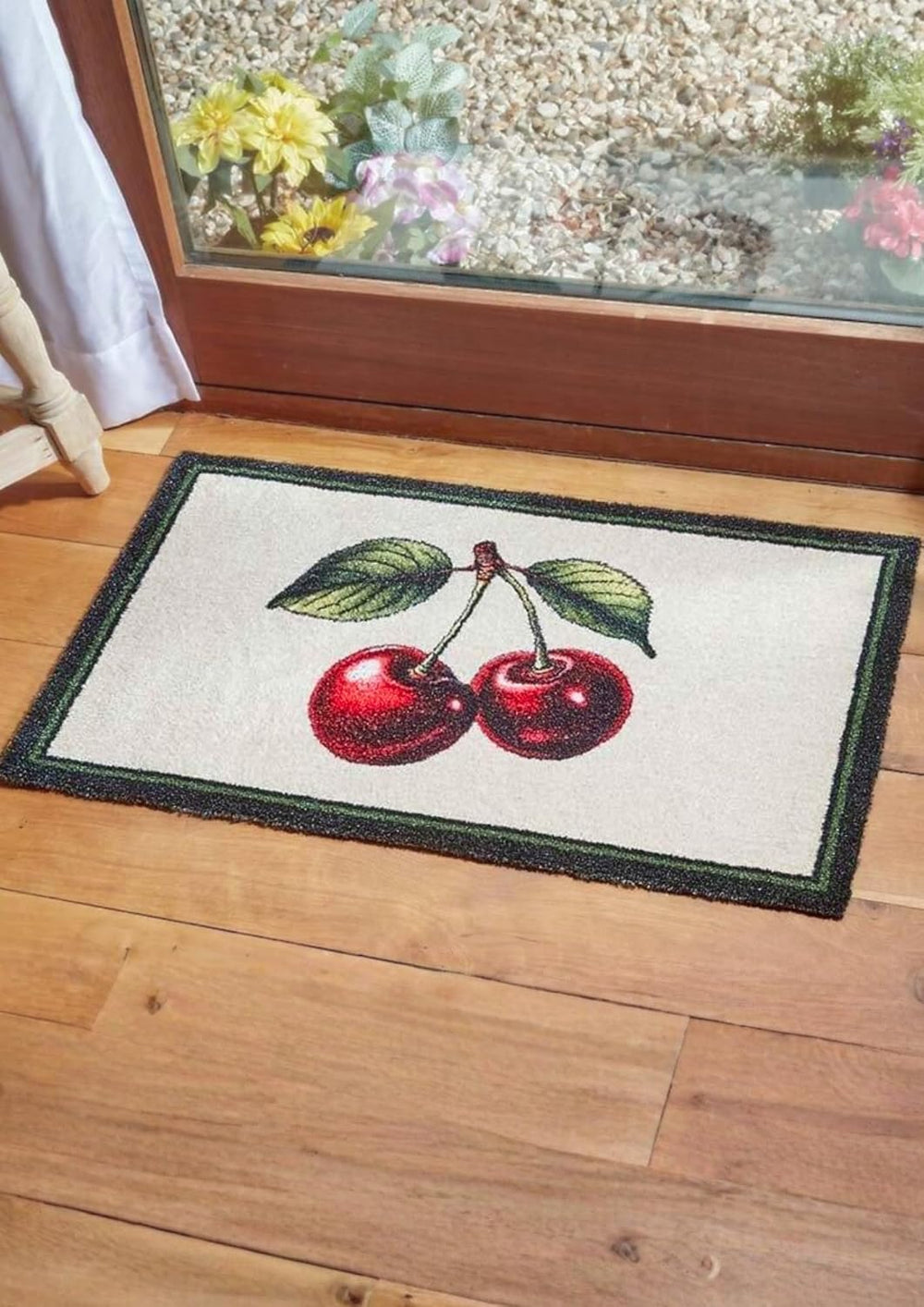 Decorative doormat with cherries on a wooden floor