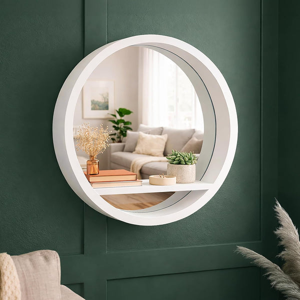 Round white mirror on a green wall with a living room reflection.