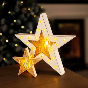 Wooden star-shaped lamps with glowing interior on a wooden surface, blurred Christmas tree in the background.