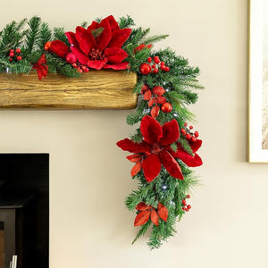 Decorative Christmas garland with red flowers and greenery on a fireplace mantle.