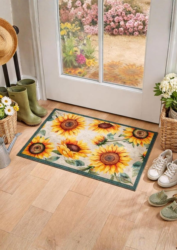 Decorative rug with sunflower pattern on a wooden floor in front of a door with floral view.