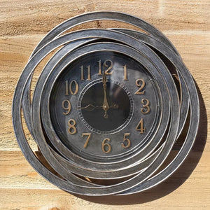 Decorative wall clock with spiral design on a wooden background