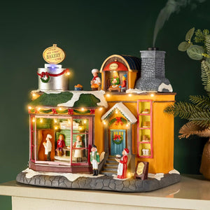 Decorative model of a bakery with animated figures and lights on a dark background