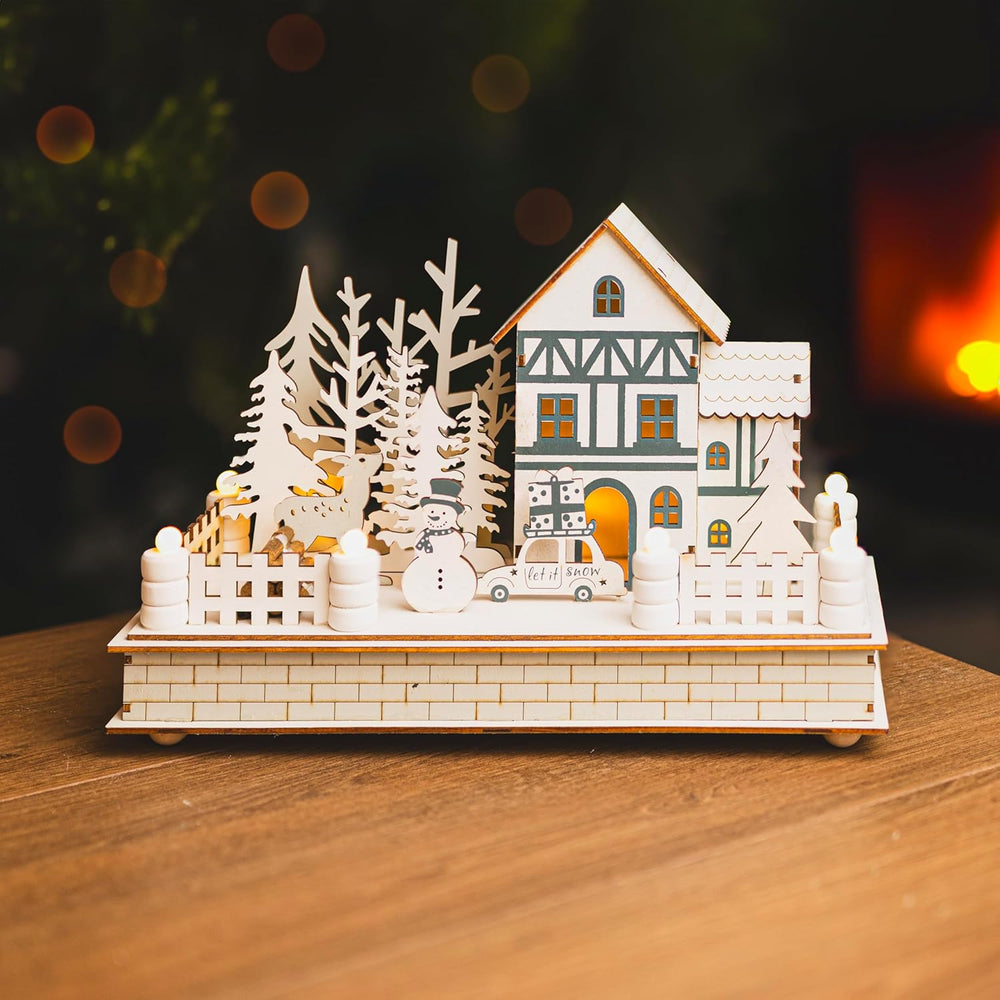 Wooden Christmas village scene with a house, trees, and car on a wooden base.