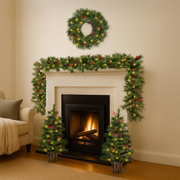 Decorated fireplace with Christmas wreath, garland, and trees in a living room.