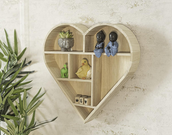 Heart-shaped wooden shelf with decorative items on a light background