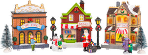 Christmas village scene with miniature buildings and figures on a white background.