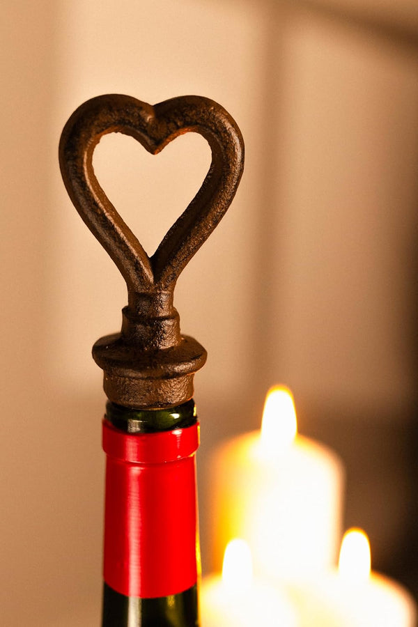 Wine bottle with a heart-shaped bottle opener against a warm background