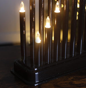 Decorative black lamp with multiple light bulbs on a wooden surface