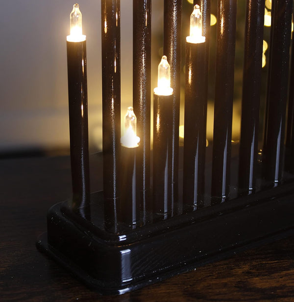 Decorative black lamp with multiple light bulbs on a wooden surface