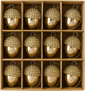 Gold acorn-shaped ornaments with beaded tops in a cardboard box.